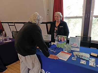 Lena speaking with a senior woman at a table