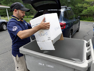 Dejan emptying box of items to shred