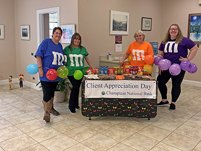 Four girls wearing M and M costumes with balloons