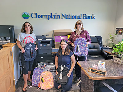 Three Women Holding School Backpacks