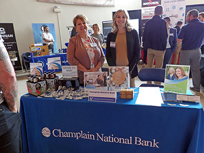 Lisa and Taylor Standing Behind a Table of Information and Giveaways