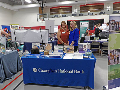 Lori and Taylor standing behind a table with brochures and posters on it