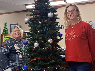 Two Women Standing with Christmas Tree