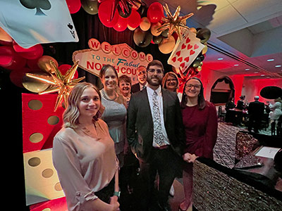 Seven People Posing in front of Las Vegas Paraphernalia